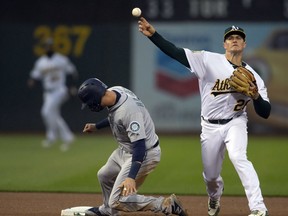 Oakland Athletics third baseman Matt Chapman (26) throws after forcing out Seattle Mariners Mitch Haniger (17) on a grounder by Kyle Seager, who was safe at first base during the fourth inning of a baseball game Tuesday, May 22, 2018, in Oakland, Calif.