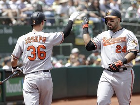 Baltimore Orioles' Pedro Alvarez (24) is congratulated by Caleb Joseph after hitting a home run against the Oakland Athletics during the second inning of a baseball game in Oakland, Calif., Sunday, May 6, 2018.