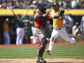 Oakland Athletics' Matt Joyce, right, scores behind Houston Astros catcher Max Stassi in the sixth inning of a baseball game Wednesday, May 9, 2018, in Oakland, Calif.