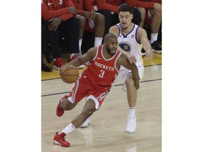 Houston Rockets guard Chris Paul (3) dribbles past Golden State Warriors guard Klay Thompson (11) during the first half of Game 3 of the NBA basketball Western Conference Finals in Oakland, Calif., Sunday, May 20, 2018.