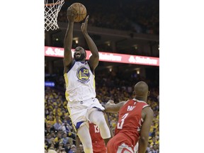 Golden State Warriors forward Draymond Green, left, shoots over Houston Rockets guard Chris Paul during the second half of Game 3 of the NBA basketball Western Conference Finals in Oakland, Calif., Sunday, May 20, 2018.