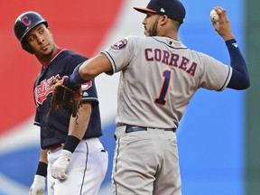 Cleveland Indians' Michael Brantley looks over at Houston Astros' Carlos Correa after Brantley hit a double during the third inning of a baseball game Friday, May 25, 2018, in Cleveland.