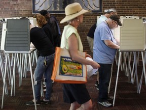 Voters fill out their ballots at the Cincinnati Public Library precinct on primary election day, Tuesday, May 8, 2018, in Cincinnati. Ohio's roller-coaster gubernatorial primary season will be decided Tuesday as Republicans and Democrats vote for their nominees to replace term-limited Republican Gov. John Kasich.