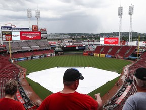 Fans wait in the stands during a rain delay before a baseball game between the Cincinnati Reds and the Pittsburgh Pirates, Tuesday, May 22, 2018, in Cincinnati.