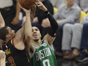 Boston Celtics' Jayson Tatum (0) drives to the basket as Cleveland Cavaliers' George Hill (3) defends in the first half of Game 3 of the NBA basketball Eastern Conference finals, Saturday, May 19, 2018, in Cleveland.