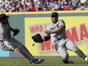 Chicago White Sox's Daniel Palka, right, cannot catch a ball hit by Cleveland Indians' Edwin Encarnacion in the fifth inning of a baseball game, Monday, May 28, 2018, in Cleveland. Yoan Moncada, left, watches. Encanacion was safe at second base for a double.
