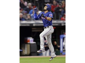 Texas Rangers' Robinson Chirinos celebrates as he runs the bases after hitting a solo home run off Cleveland Indians starting pitcher Trevor Bauer in the seventh inning of a baseball game, Monday, April 30, 2018, in Cleveland.