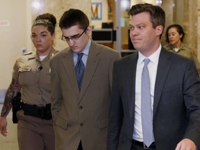 FILE - In this Tuesday, April 17, 2018 file photo, Michael Bever, center, is led from a courtroom following jury selection in his trial in Tulsa, Okla. At right is his defense attorney Corbin Brewster. Michael Bever, the younger of two brothers accused of fatally stabbing their parents and three siblings inside a suburban Oklahoma home, has been found guilty. Jurors handed down the verdict during the fourth week of the trial of Michael Bever, 19, who was charged with five counts of first-degree murder and one count of assault and battery with intent to kill for his role in the July 2015 stabbings.