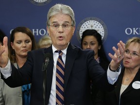 FILE - In this Wednesday, March 28, 2018 file photo, former U.S. Sen. Tom Coburn speaks at a news conference in Oklahoma City. Coburn announced his support of an anti-tax group Oklahoma Taxpayers Unite. The anti-tax group is taking advantage of a rarely used provision of the Oklahoma Constitution to try and throw out hundreds of millions of dollars in new revenue approved by the Legislature to provide new funding for teacher raises and public schools.