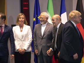 From left, German Foreign Minister Heiko Maa,  European Union foreign policy chief Federica Mogherini, Iranian Foreign Minister Javad Zarif, French Foreign Minister Jean-Yves Le Dria, and Britain's Foreign Minister Boris Johnson prepare to pose for a photo during a meeting of the foreign ministers from Britain, France and Germany with the Iran Foreign Minister and EU foreign policy chief Federica Mogherini, at the Europa building in Brussels, Tuesday, May 15, 2018. Major European powers sought Tuesday to keep Iran committed to a deal to prevent it from building a nuclear bomb despite deep misgivings about Tehran's Middle East politics and President Donald Trump's vehement opposition.