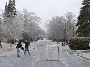 Two boys play hockey and skate on Fairmeadow Cres. in Ottawa Monday April 16, 2018 after an ice storm.
