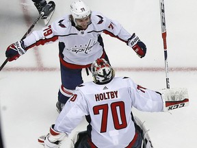 Washington Capitals goaltender Braden Holtby (70) joins the celebration with a hug from Nathan Walker