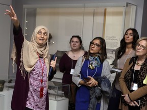 In this April 26, 2018 photo, Moumena Saradar, left, originally from Syria, guides visitors through the Middle East gallery at Penn Museum, in Philadelphia. The University of Pennsylvania Museum of Archaeology and Anthropology is in the midst of dramatic renovations, opening new galleries to showcase previously undisplayed items, telling the stories of those artifacts in more relatable ways and adding guides native to the parts of the world being showcased.