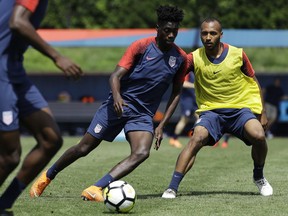United States' Tim Weah, center, and Julian Green battle for the ball during soccer practice at the University of Pennsylvania in Philadelphia, Wednesday, May 23, 2018.