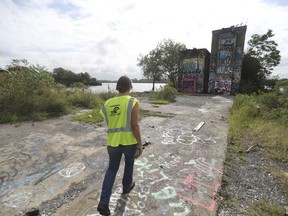 In this Sept. 19, 2017 photo, Contrail's Jocelyn Gabrynowicz Hill walks the Port Richmond rail yard and "Graffiti Pier" in Philadelphia.   The popular public art space called Graffiti Pier has been shut down by police over safety concerns, prompting a push to have the former coal pier-turned-outdoor museum made into an official park as a way to save it from the fate of other graffiti meccas that were razed by developers.