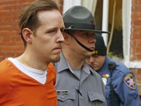 FILE – In this Oct. 31, 2014, file photo, Eric Frein, left, is escorted out by police after his arraignment at the Pike County Courthouse in Milford, Pa. Lawyers for Frein, on death row for fatally shooting Pennsylvania State Police Cpl. Bryon Dickson II and wounding Trooper Alex Douglass in Sept. 2014, were scheduled to argue before the state Supreme Court on Thursday, May 17, 2018, that the justices should throw out Frein's conviction.