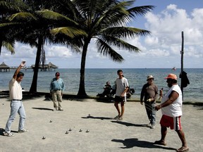 FILE - In this Thursday, Sept. 22, 2005 file photo, locals on the beach in Noumea, New Caledonia, play the traditional ball game "petanque".  French President Emmanuel Macron starts Thursday a highly symbolic visit to New Caledonia, a French territory in the South Pacific which is getting ready to vote in a self-determination referendum to decide on its own sovereignty.