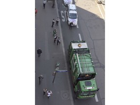 Police officers stand next to a waste truck in Paris, France, Friday, May 25, 2018. Paris police said two garbage collectors have been arrested after they stole a waste truck in order to discharge it in front of French President Emmanuel Macron's party headquarters. (AP Photo)