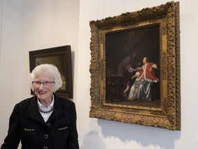 Ninety-seven-year-old Charlotte Bischoff van Heemskerck poses next to the painting "The Oyster Meal" by Jacob Ochtervelt (1634-1682) at Sotheby's in Amsterdam, Netherlands, Tuesday, May 1, 2018. The Dutch Old Master painting, belonging to Charlotte's father, was looted by the Nazis in the dying days of World War II and is being put up for auction after it was discovered hanging in the official residence of the Lord Mayor of the City of London and returned late last year to its rightful owners.