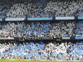 Manchester City fans cheer prior to the English Premier League soccer match between Manchester City and Huddersfield Town at Etihad stadium in Manchester, England, Sunday, May 6, 2018.
