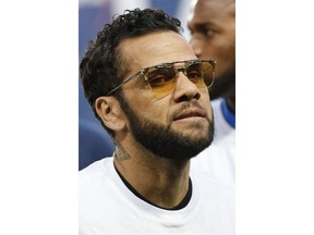 Injured Dani Alves takes his seat on the bench prior to the League One soccer match between Paris Saint-Germain and Stade Rennais at the Parc des Princes stadium in Paris, Saturday May 12, 2018. Alves will most likely miss the World Cup due to a knee injury.