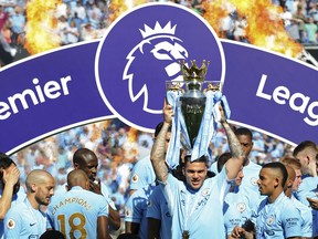 Manchester City's goalkeeper Ederson Moraes lifts the English Premier League trophy after the soccer match between Manchester City and Huddersfield Town at Etihad stadium in Manchester, England, Sunday, May 6, 2018.