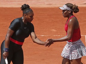 Venus, right, and Serena Williams of the U.S. celebrate after scoring a point against Japan's Shuko Aoyama and Miyu Kato during their women's doubles first round match of the French Open tennis tournament at the Roland Garros stadium in Paris, France, Wednesday, May 30, 2018.