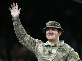 FILE - In this May 13, 2016, file photo, Oregon Army National Guard specialist Aleksander Reed Skarlatos waves to the crowd during a tribute in the fourth inning of a baseball game between the Boston Red Sox and the Houston Astros in Boston. Roseburg, Ore, resident Skarlatos, who helped stop a gunman on a train traveling from Amsterdam to Paris in August 2015, announced his candidacy Tuesday, May 15, 2018, for Douglas County commissioner.