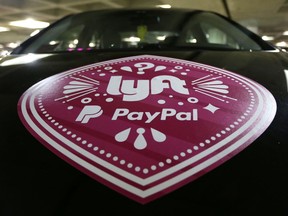 FILE - In this March 31, 2016, a Lyft ride-hailing service logo is displayed on a vehicle at Seattle-Tacoma International Airport in Seattle. A federal appeals court has reinstated a challenge to Seattle's first-in-the-nation law allowing drivers of ride-hailing companies such as Uber and Lyft to unionize.