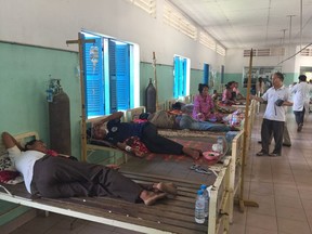 In this May 5, 2018, photo is provided by Cambodia National Police, patients, who sickened from drinking water, lie on the beds in a hospital at Kratie province in northeastern of Phnom Penh, Cambodia.  A health official says several Cambodian villagers have died and more than a hundred of others are sickened after drinking water suspected to be contaminated with insecticide. (Cambodia National Police via AP)