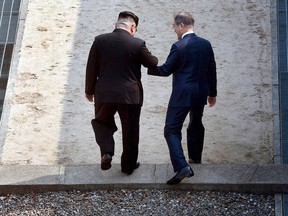 North Korean leader Kim Jong Un, left, and South Korean President Moon Jae-in cross the military demarcation line at the border village of Panmunjom in Demilitarized Zone Friday, April 27, 2018.