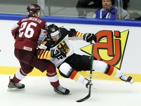 Latvia's Uvis Balinskis, left, collides with Germany's Markus Eisenschmid, right, during the Ice Hockey World Championships group B match between Latvia and Germany at the Jyske Bank Boxen arena in Herning, Denmark, Saturday, May 12, 2018.