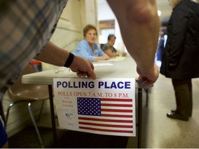 An election official affixes a sign for the 2018 Pennsylvania Primary Election at the Hazleton City Hall polling station on May 15, 2018 in Hazleton, Pennsylvania.  In the second major May primary day nationwide, four states go to the polls: Idaho, Nebraska, Oregon, and Pennsylvania.