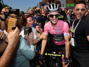 Britain's Simon Yates poses with fans prior to the 18th stage of the Giro d'Italia cycling race, from Abbiategrasso to Prato Nevoso, in Abbiategrasso, Italy, Thursday, May 24, 24,  2018.