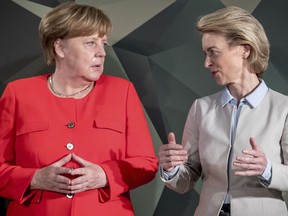 German Chancellor Angel Merkel, left, talks to defense minister Ursula von der Leyen to her visit to a Bundeswehr meeting in Berlin, Germany, Monday, May 14, 2018.