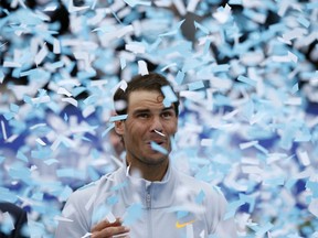 FILE - In this April 29, 2018 file photo, Spain's Rafael Nadal reacts to falling confetti after winning the Barcelona Open Tennis Tournament final in Barcelona, Spain. As a longtime Real Madrid supporter, Nadal appeared with a Atletico Madrid jersey in Atletico's Europa League match against Arsenal on Thursday May 3, 2018, making headlines and attracting a wave of social media reactions by fans from both clubs.