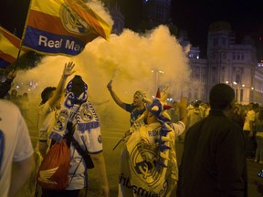 Real Madrid fans celebrate after lighting a flare in downtown Madrid, Spain, Saturday, May 26, 2018. Real Madrid defeated Liverpool in Kiev, Ukraine, to win the Champions League soccer match final.