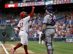Philadelphia Phillies' Odubel Herrera, left, reacts after hitting a home run off New York Mets starting pitcher Steven Matz during the first inning of a baseball game Friday, May 11, 2018, in Philadelphia. At right is catcher Devin Mesoraco.