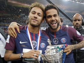 PSG's Neymar, left, and his teammate Dani Alves pose with the French Cup 2018 trophy at the Stade de France stadium in Saint-Denis, outside Paris, Tuesday, May 8, 2018. Paris Saint-Germain beat resilient third-division side Les Herbiers 2-0 to win the French Cup.