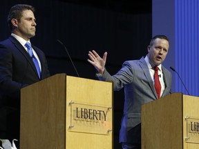 FILE - In this April 19, 2018 file photo Republican primary senatorial candidate Corey Stewart, right, gestures as Del. Nick Freitas listens during a debate at Liberty University in Lynchburg, Va.  The vicious tenor of the 2016 GOP presidential primary is being matched by Virginia's raucous congressional primaries. In primaries for the U.S. House and the Senate seat held by Democratic Tim Kaine, there's been a near constant stream of complaints of below-the-belt attacks or shady campaigning. Some candidates bemoan the negative tone while others say it's not a problem.