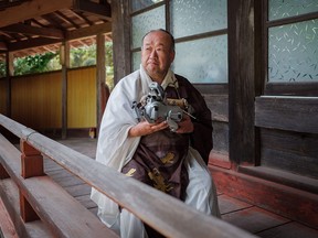 Kofukuji Temple chief priest Bungen Oi holds an Aibo after a funeral for 114 robodogs at the temple in Isumi, Japan, on April 26, 2018.