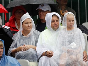 Spectators wearing rain coats watch Bethanie Mattek-Sands of the U.S. playing Sweden's Johanna Larsson during their first round match of the French Open tennis tournament at the Roland Garros stadium, Tuesday, May 29, 2018 in Paris.