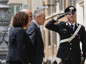 New premier-designate Carlo Cottarelli, center, is saluted by a Carabiniere paramilitary police officer as he arrives at the Lower Chamber palace, after meeting with Italian President Sergio Mattarella, at the Quirinale Presidential Palace, in Rome, Monday, May 28, 2018. Cottarelli was tapped on Monday to lead Italy to early elections, possibly as soon as after the summer, after populist political forces failed to convince the president their Cabinet picks wouldn't destroy the faith of the markets and other investors.