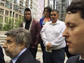 Daniel Ramirez Medina, center right in light-colored shirt, listens as two of his lawyers, Mark Rosenbaum, left, and Nathaniel Bach, right, address reporters following a hearing in U.S. District Court in Seattle on Tuesday, May 1, 2018. Ramirez is asking U.S. District Judge Ricardo S. Martinez to block the government from revoking his participation in the Deferred Action for Childhood Arrivals program, which allows those brought to the U.S. illegally as children to remain in the country to work or study.