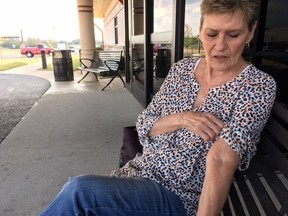 In a Nov. 15, 2017 photo, Cherokee citizen Judith Anderson examines the scar tissue on her left arm from years of IV drug use outside the Redbird Smith Health Center in Sallisaw, Okla. Anderson is among hundreds of tribal citizens who have tested positive for hepatitis C in the past three years because of dangerous drug use. She's being treated for the potentially fatal liver disease thanks to a hepatitis C eradication program launched in 2015 by the tribe, partly to respond to the nation's opioid epidemic.