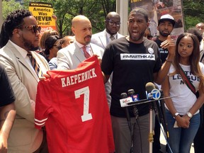 New York Councilman Jumaane D. Williams, second from right, with the help of  Kirsten John Foy, second from left, Northeast Regional Director of the National Action Network, holds a jersey with Colin Kaepernick's name on the back, during a rally of civil rights activists outside of the NFL's headquarters, Friday, May 25, 2018, in New York. About 50 people gathered to protest the NFL's new policy aimed at ending player protests during the playing of the national anthem in stadiums before games. Kaepernick, the former San Francisco 49ers quarterback, started the movement of taking a knee during the anthem to protest police brutality and racial inequality two seasons ago.