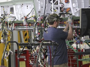 In this Wednesday, April 25, 2018, photo, workers perform hydraulics testing on a new F/A-18 at Boeing's fighter aircraft production line in St. Louis. The Pentagon has the biggest budget in history this year, with $700 billion to spend on defense, including new fighter aircraft.