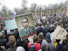 Demonstrators carry a poster depicting Russian President Vladimir Putin as the elderly Soviet Communists party leader Leonid Brezhnev, during a massive protest rally in St.Petersburg, Russia, Saturday, May 5, 2018. Alexei Navalny, anti-corruption campaigner and Putin's most prominent critic, called for nationwide protests on Saturday, two days ahead of the inauguration of Vladimir Putin for a fourth term as Russian president.