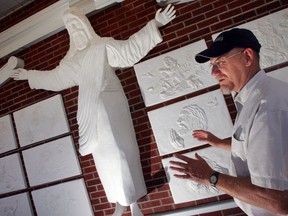 This 2017 file photo  Bert Baker, an amateur artist, stands in front of a recently finished seven-foot tall sculpture of Christ at Red Bank Baptist Church in Lexington, S.C.  The sculptor says his statue of Jesus Christ is being removed from a the church after more than a decade, because some perceive it as "too Catholic" for the Baptist place of worship.