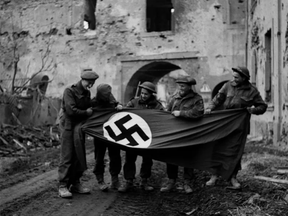 Canadian soldiers display a Nazi flag removed from a building in Xanten, Germany as the Second World War was coming to an end in 1945.